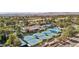 Aerial view of community, including multiple tennis courts and community pool surrounded by mature trees at 7315 Mission Hills Dr, Las Vegas, NV 89113