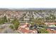 Expansive aerial view of a community with red tile roofs, lush trees, and mountain views in the distance at 7315 Mission Hills Dr, Las Vegas, NV 89113