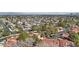 Expansive aerial view of a community with red tile roofs, lush trees, and city views in the distance at 7315 Mission Hills Dr, Las Vegas, NV 89113
