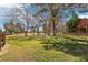 Expansive backyard featuring lush green grass and mature trees offering ample shade at 7315 Mission Hills Dr, Las Vegas, NV 89113