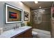 Bathroom featuring sleek vanity, modern mirror, and glass-enclosed tub and shower at 7315 Mission Hills Dr, Las Vegas, NV 89113