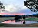 Scenic view of the golf course and pond, reflecting a vibrant sunset and mountain views at 7315 Mission Hills Dr, Las Vegas, NV 89113