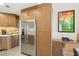 Contemporary kitchen with stainless steel refrigerator, custom wood cabinets, and tile backsplash at 7315 Mission Hills Dr, Las Vegas, NV 89113