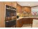 Modern kitchen with stainless steel ovens, granite countertops, custom wood cabinets and tile backsplash at 7315 Mission Hills Dr, Las Vegas, NV 89113