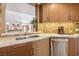Modern kitchen counter featuring granite counters, stainless steel dishwasher, and custom wood cabinets at 7315 Mission Hills Dr, Las Vegas, NV 89113