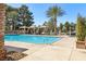 Relaxing pool area surrounded by tall trees and lounge chairs in cabanas with views of mature landscaping at 7315 Mission Hills Dr, Las Vegas, NV 89113