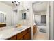 Well-lit bathroom with double vanity, white marble countertop, and neutral-colored tiles at 7682 Calm Passage Ct, Las Vegas, NV 89139