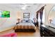 Cozy bedroom features a ceiling fan, a flatscreen TV, and bedside tables with lamps at 7682 Calm Passage Ct, Las Vegas, NV 89139