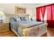 Bedroom with a large bed, hardwood floors and red curtains at 7682 Calm Passage Ct, Las Vegas, NV 89139