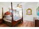This bedroom has a four-poster bed, wood floors, and a golden ornate mirror at 7682 Calm Passage Ct, Las Vegas, NV 89139