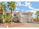 Elegant two-story home with a balcony, arched windows and mature palm trees at 7682 Calm Passage Ct, Las Vegas, NV 89139