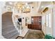 Grand foyer with a sweeping staircase, chandelier, and elegant decor at 7682 Calm Passage Ct, Las Vegas, NV 89139