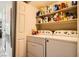 Bright laundry room features a white washer and dryer set with shelving for storage at 7950 W Flamingo Rd # 1081, Las Vegas, NV 89147