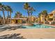Community pool featuring a central island with palm trees, covered seating, and lounge space at 7950 W Flamingo Rd # 1081, Las Vegas, NV 89147