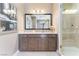 Bathroom vanity with double sinks, large mirror, and an adjacent glass shower at 8042 Skye Bridge St, Las Vegas, NV 89166