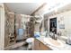 Bathroom featuring shower with glass door, granite countertops, and closet in mirror reflection at 8440 Wandering Sun Ave, Las Vegas, NV 89129