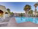 Inviting community pool, surrounded by lounge chairs, a shaded patio, and manicured palm trees at 8440 Wandering Sun Ave, Las Vegas, NV 89129
