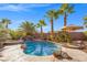 Backyard oasis features a sparkling pool with rock waterfall and lush landscaping at 1065 Otto Ridge Ct, Henderson, NV 89052