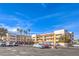 Exterior view of a multi-story apartment building with a parking lot and palm trees at 1381 E University Ave # 204, Las Vegas, NV 89119
