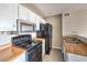 Compact kitchen features white cabinetry, wood countertops, and black appliances at 1381 E University Ave # 204, Las Vegas, NV 89119
