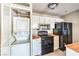 This kitchen has a stackable washer-dryer, fridge and white cabinets at 1381 E University Ave # 204, Las Vegas, NV 89119