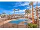 Community pool featuring clear blue water, palm trees, lounge chairs, and apartment buildings in the background at 1381 E University Ave # 204, Las Vegas, NV 89119