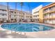 Resort-style pool featuring clear blue water, lounge chairs, and apartment buildings with balconies at 1381 E University Ave # 204, Las Vegas, NV 89119