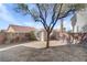 View of the backyard with a storage shed and mature tree, surrounded by a brick wall at 2573 Rafferty Creek Ln, Las Vegas, NV 89156