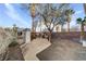Spacious backyard featuring a brick wall, storage shed, and mature trees at 2573 Rafferty Creek Ln, Las Vegas, NV 89156