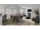 Open-concept dining room featuring fireplace, large windows and modern lighting at 2573 Rafferty Creek Ln, Las Vegas, NV 89156