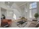 Bright living room with vaulted ceilings, wood floors, staircase, and large windows at 2573 Rafferty Creek Ln, Las Vegas, NV 89156