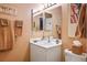 Bathroom featuring single vanity, toilet, decorative art, and neutral-toned walls at 283 New River Cir, Henderson, NV 89052