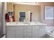 Bathroom featuring double vanity, framed mirrors, large counters, and bathtub in the background at 283 New River Cir, Henderson, NV 89052