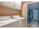 Functional laundry room with washer, dryer, cabinets, and doorway to garage for easy access at 283 New River Cir, Henderson, NV 89052