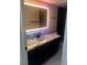Modern bathroom with a brightly lit mirror, new countertop and dark cabinets at 2970 Juniper Hills Blvd # 102, Las Vegas, NV 89142