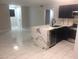 Bright, open-plan kitchen featuring marble floors, dark blue cabinets, and a marble countertop island at 2970 Juniper Hills Blvd # 102, Las Vegas, NV 89142