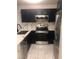 A modern kitchen with stainless steel appliances, dark cabinets, and a light marble countertop at 2970 Juniper Hills Blvd # 102, Las Vegas, NV 89142