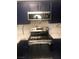 Modern kitchen showcasing dark cabinets, a stainless steel microwave, and a range oven at 2970 Juniper Hills Blvd # 102, Las Vegas, NV 89142