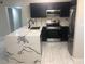 A modern kitchen with white floors, dark blue cabinets, stainless steel appliances, and marble countertops at 2970 Juniper Hills Blvd # 102, Las Vegas, NV 89142