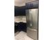 Kitchen with dark blue cabinets, stainless steel appliances, and a marble backsplash and countertop at 2970 Juniper Hills Blvd # 102, Las Vegas, NV 89142