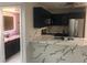 Modern kitchen with a marble waterfall island, stainless steel appliances and bathroom view at 2970 Juniper Hills Blvd # 102, Las Vegas, NV 89142