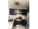 Well-lit kitchen featuring stainless steel appliances and contrasting dark-colored cabinetry at 2970 Juniper Hills Blvd # 102, Las Vegas, NV 89142