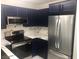 A modern kitchen showcasing dark cabinets, stainless steel appliances, and marble countertops at 2970 Juniper Hills Blvd # 102, Las Vegas, NV 89142