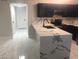 Stylish kitchen with marble countertops, modern black cabinets, and tile floors at 2970 Juniper Hills Blvd # 102, Las Vegas, NV 89142