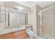 Well-lit bathroom featuring a marble-top vanity, large mirror, and tiled walk-in shower with glass door at 3367 Trickling Stream Cir, Las Vegas, NV 89117