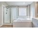 Bathroom featuring separate shower and tub plus glass block window at 3401 Bedfordshire Pl, Las Vegas, NV 89129