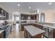 View of the kitchen with stainless steel appliances, dark wood cabinets and a center island at 3401 Bedfordshire Pl, Las Vegas, NV 89129