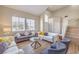 Sunlit living room with high ceilings, wood-look floors, and modern furnishings at 3401 Bedfordshire Pl, Las Vegas, NV 89129