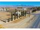 Expansive aerial view of the property, featuring mature trees, adjacent buildings, and mountain views at 3780 E Kellogg Rd, Pahrump, NV 89061