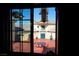 View through a window of a charming courtyard with outdoor dining set, plants, and decorative statues offering a serene retreat at 3780 E Kellogg Rd, Pahrump, NV 89061